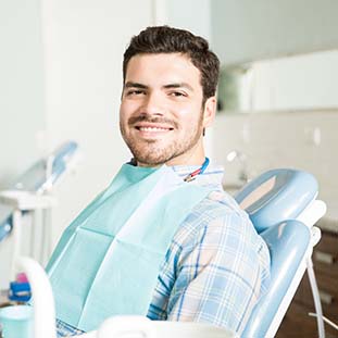 smiling man sitting in a dental chair