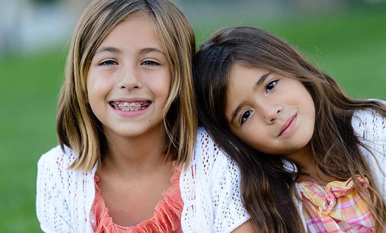 two young girls wearing braces