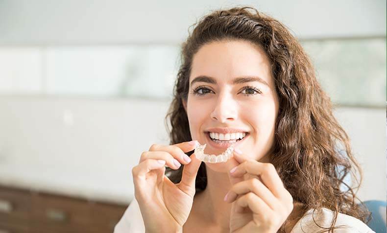 woman putting on her clear aligner