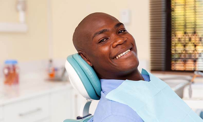 smiling man sitting in a dental chair