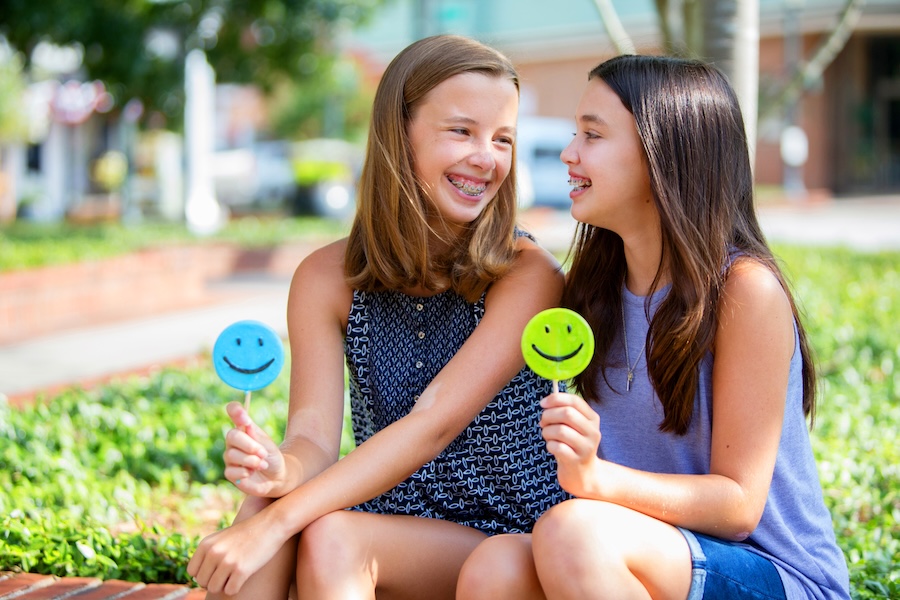 smiling young girls in braces, orthodontic care to establish healthy smiles
