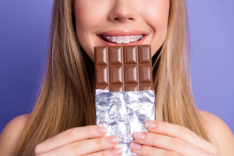 teen with braces eating candy at halloween